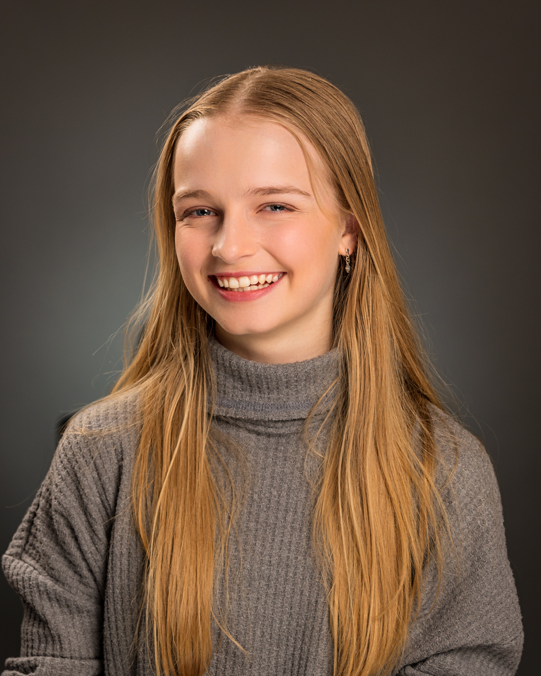 a young girls with parted hair smiling towards the camera