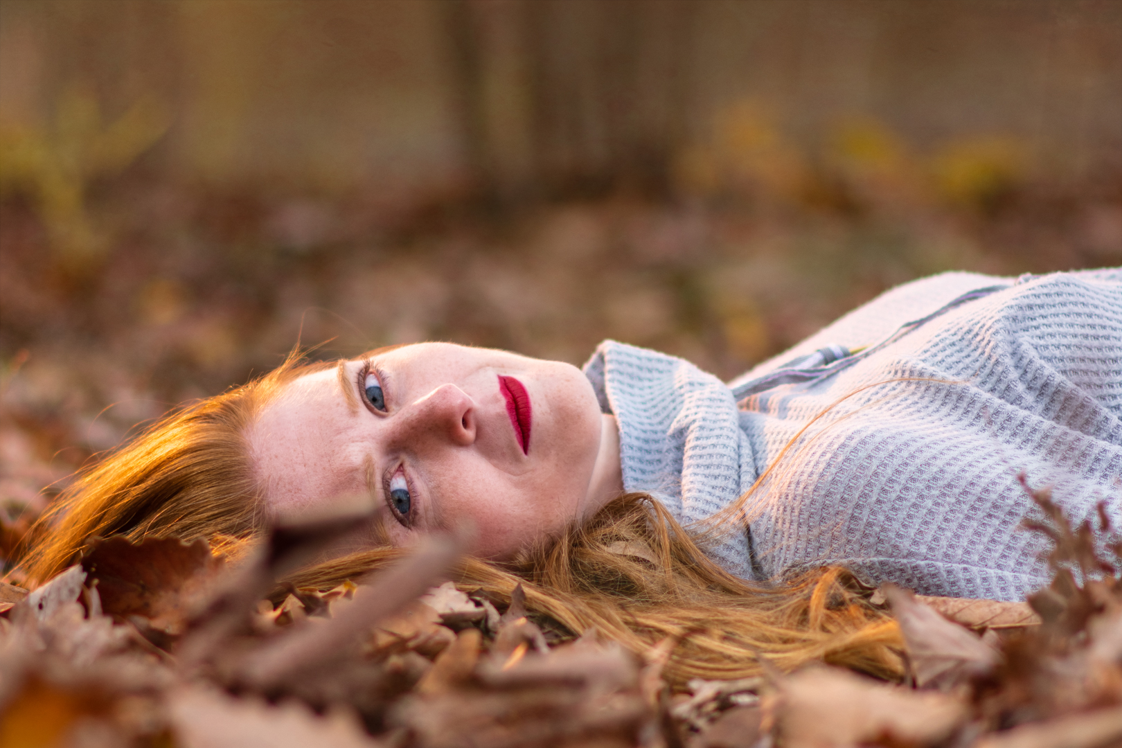 a woman laying on the ground with her eyes to the camera