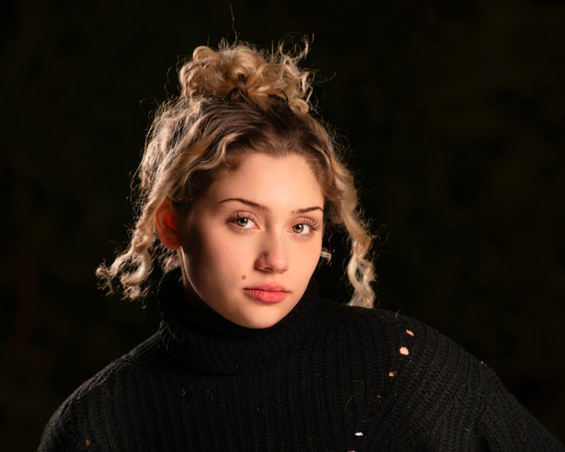 a young woman with blonde hair wearing a black sweater